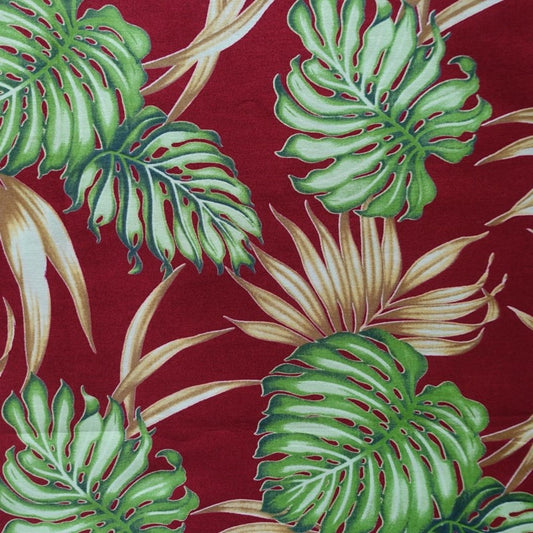 Détail motif Monstera et feuillages vert émeraude menthe sur fond rouge bordeaux 100% coton
