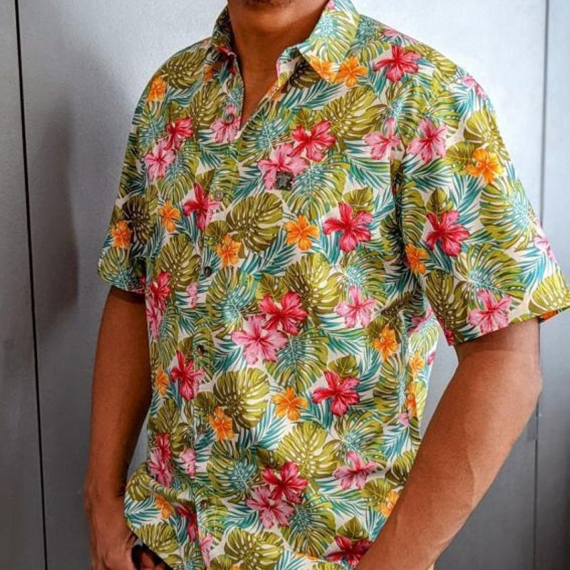 Homme portant une chemise tahitienne motifs hibiscus rose et orange et monstera sur fond blanc