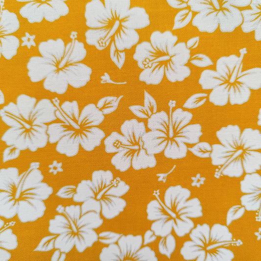 Détails tissu tahitien en coton motifs petits hibiscus blanc sur fond jaune