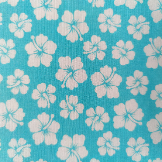 Détails tissu tahitien en coton motifs petits hibiscus blanc sur fond turquoise