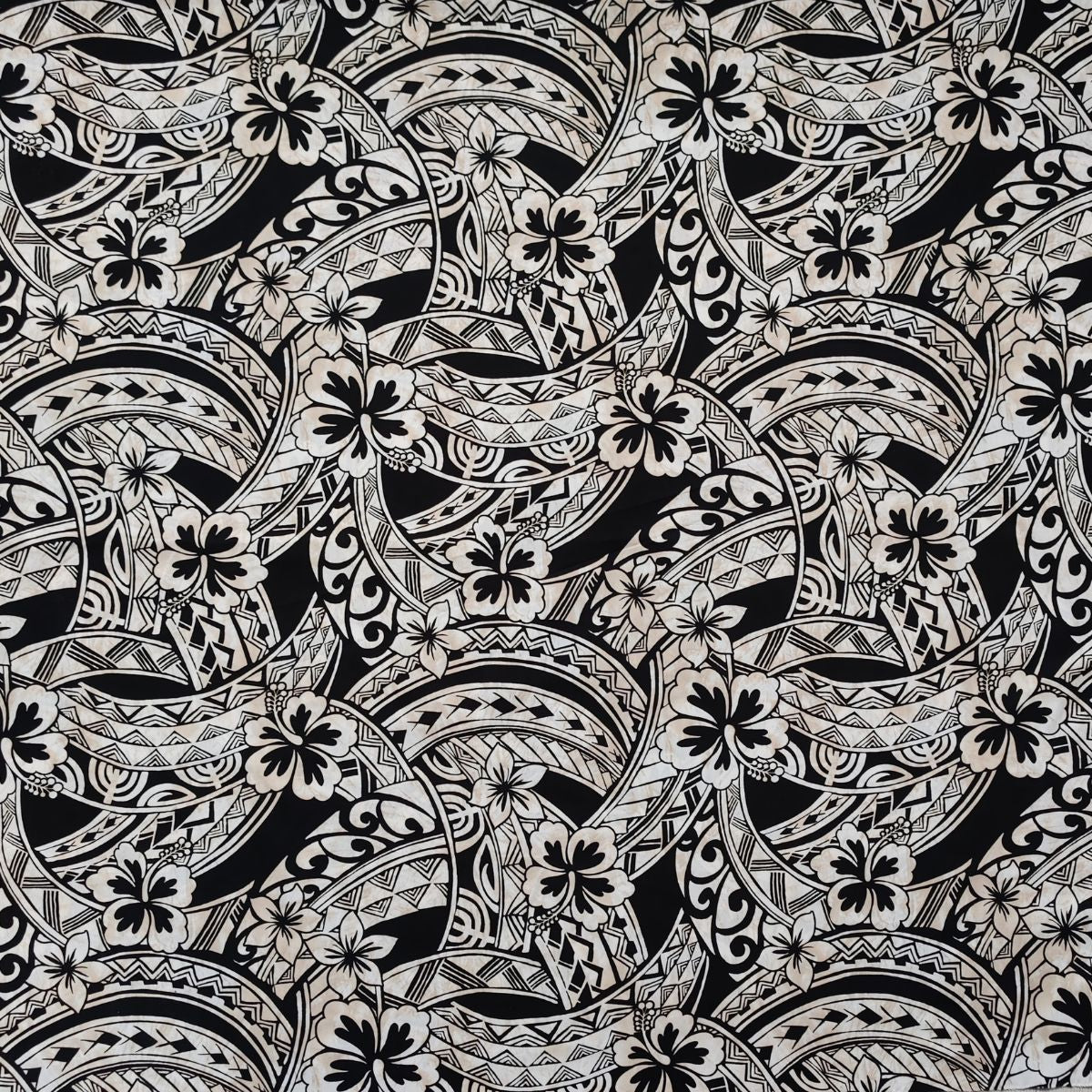 Tissu coton polynésien motifs hibiscus et tatouages géométriques beige sur fond noir profond - Couleurs du Fénua