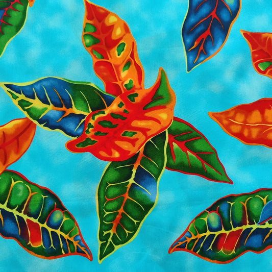 Tissu tahitien en coton, zoom sur les motifs crotons orange et vert sur fond bleu turquoise. Tissu exclusif - dernier coupon. Aucun réassort.