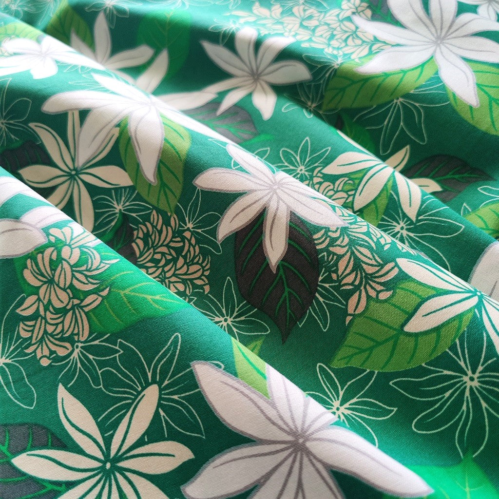 Tissu tahitien en coton, motifs fleurs de tiarés blanches sur fond vert lumineux. Aucun réassort, dernier métrage.