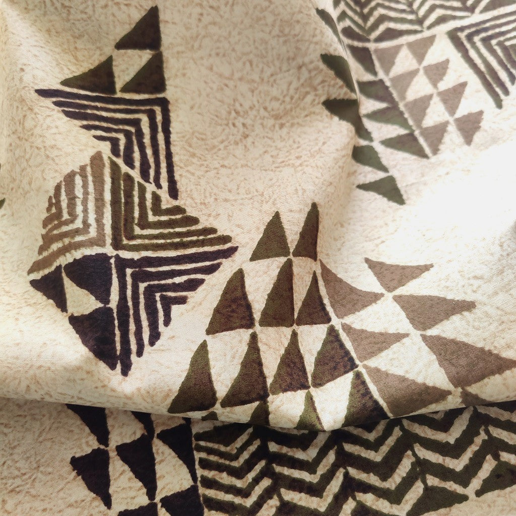 Tissu tahitien en coton, gros plan sur les motifs marquisiens géométriques marrons sur fond beige - Stock limité