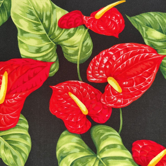 Tissu tahitien en viscose, zoom sur le motif anthurium rouge lumineux sur fond noir profond. Pas de réassort pour ce tissu.
