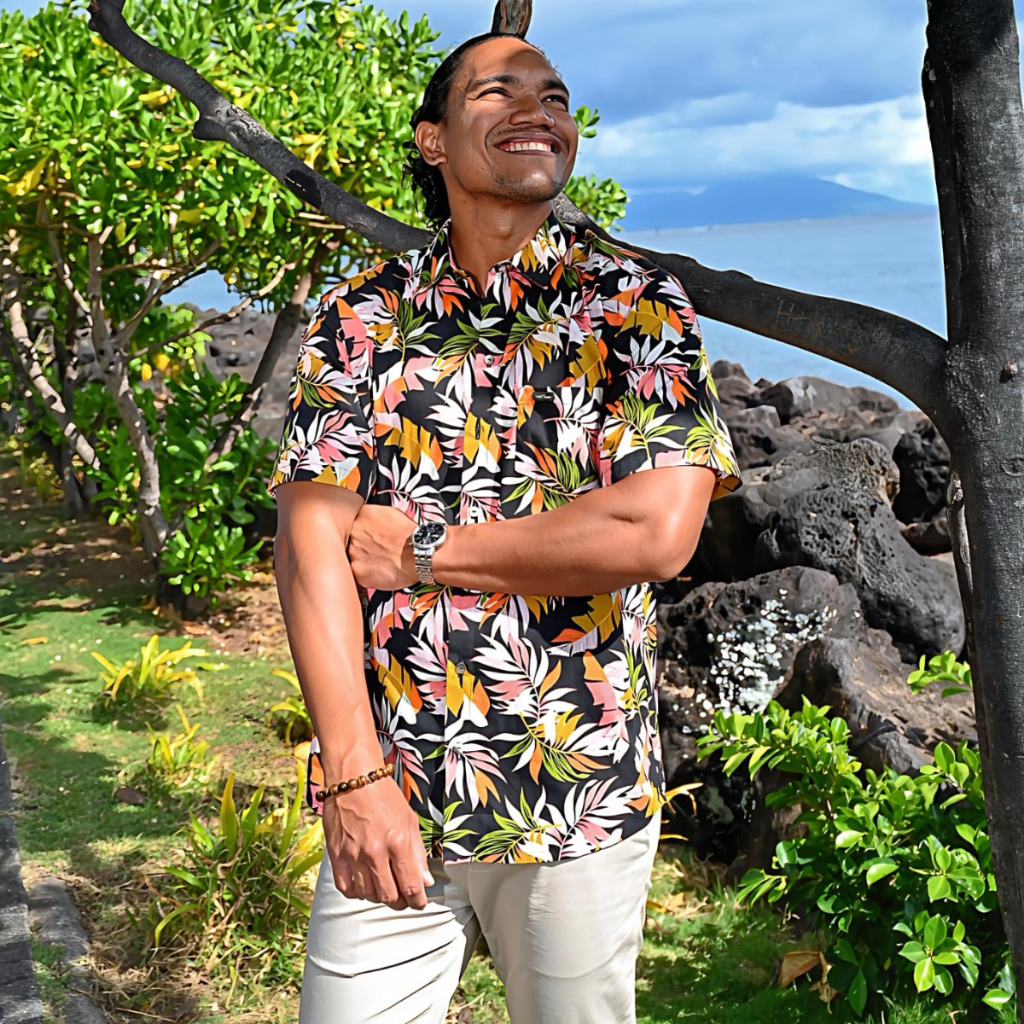 chemise polynésienne pour homme en tissu tahitien, motifs feuilles de bananaiers et fougères multicolores sur fond noir lumineux - Tahiti Tropic