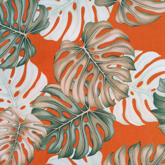 Détail motif Monstera aquarelle vert sauge beige sur fond orange éclatant 100% coton