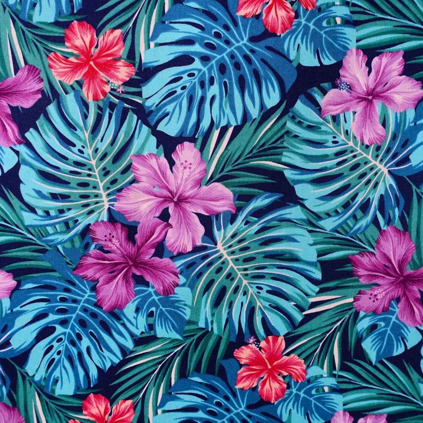 Détail motif Hibiscus rose fuschia orange corail et Monstera bleu turquoise sur fond bleu nuit 100% coton