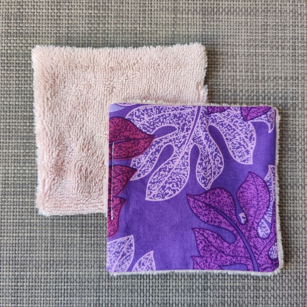 Lingette lavable 10 x 10, une face en tissu tahitien monstera violet en coton et une face en éponge bambou tout doux. 