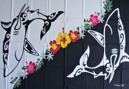 Paréo en fibranne représentant des requins polynésiens noir et blanc séparés par une couronne de fleurs tropicales. 175 x 115 cm