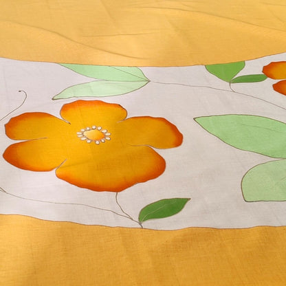 Gros plan sur l'hibiscus du paréo tahitien en voile de coton, peint à la main à Tahiti, motifs hibiscus orange et blanc. Paréo artisanal traditionnel