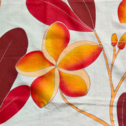 Paréo tahitien en voile de coton, peint à la main à Tahiti, motifs frangipaniers orange sur fond rouge et blanc. Paréo artisanal traditionnel