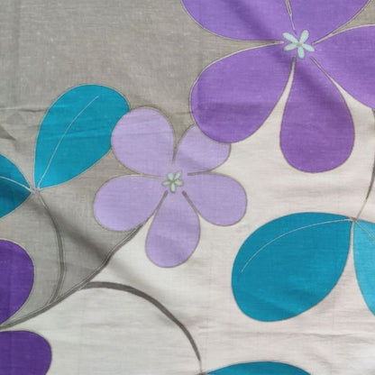 zoom sur le paréo tahitien en voile de coton, peint à la main à Tahiti, motifs tiarés violet et bleu sur fond gris et blanc. Paréo artisanal traditionnel