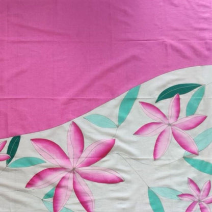 Détails du paréo tahitien en voile de coton, peint à la main à Tahiti, motifs tiarés rose sur fond blanc. Paréo artisanal traditionnel