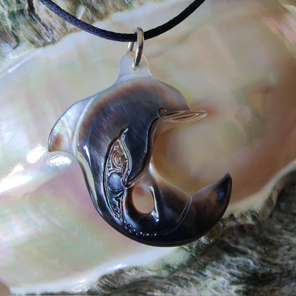 Pendentif Dauphin en nacre gravée de tahiti. Bijou polynésien artisanal aux reflets naturels irisés