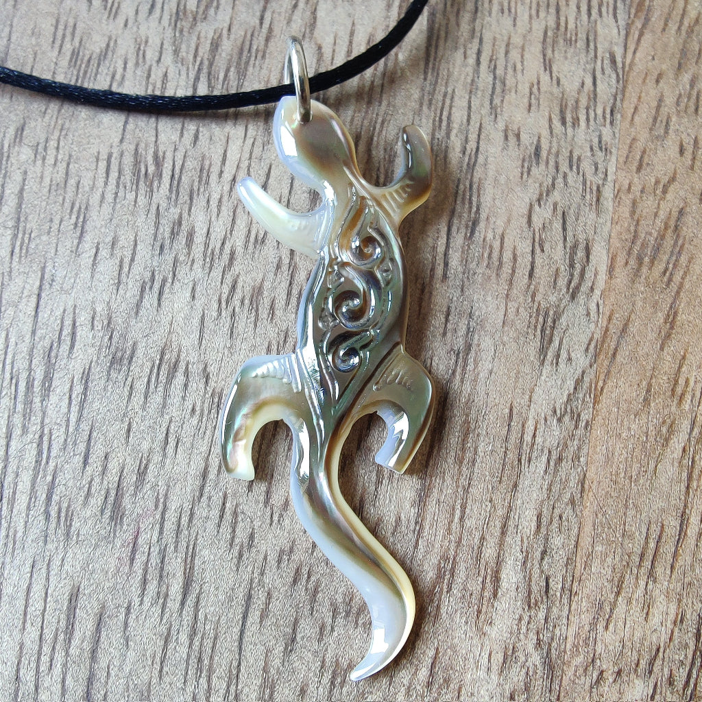 Pendentif geckko margouillat en nacre gravée de Tahiti. Bijou polynésien artisanal monté sur lien noir ajustable.
