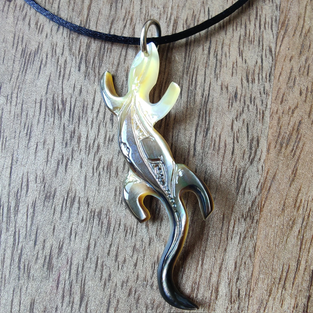 Pendentif geckko margouillat en nacre gravée de Tahiti. Bijou polynésien artisanal monté sur lien noir ajustable.