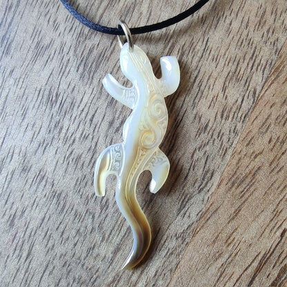 Pendentif geckko margouillat en nacre gravée de Tahiti. Bijou polynésien artisanal monté sur lien noir ajustable.