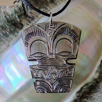 Pendentif Tiki en nacre gravée de Tahiti, monté sur lien noir ajustable. Bijou polynésien symbole de guerrier protecteur.