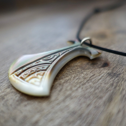 Pendentif Pénu en nacre de Tahiti, inspiré du pilon traditionnel polynésien. Monté sur lien ajustable noir, aux reflets irisés