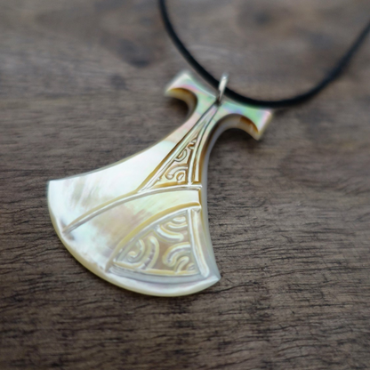 Pendentif Pénu en nacre de Tahiti, inspiré du pilon traditionnel polynésien. Monté sur lien ajustable noir, aux reflets blancs irisés