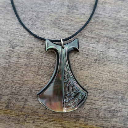 Pendentif Pénu en nacre de Tahiti, inspiré du pilon traditionnel polynésien. Monté sur lien ajustable noir, aux reflets irisés