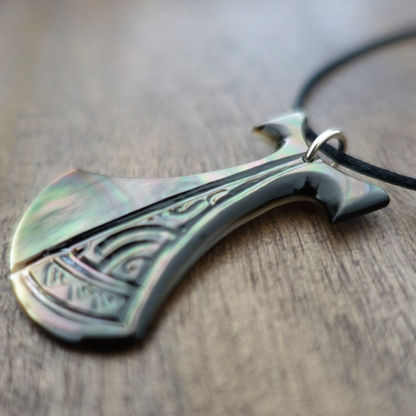 Pendentif Pénu en nacre de Tahiti, inspiré du pilon traditionnel polynésien. Monté sur lien ajustable noir, aux reflets irisés