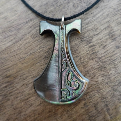 Pendentif Pénu en nacre de Tahiti, inspiré du pilon traditionnel polynésien. Monté sur lien ajustable noir, aux reflets irisés