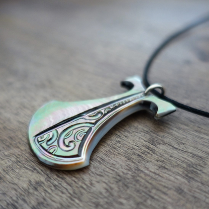 Pendentif Pénu en nacre de Tahiti, inspiré du pilon traditionnel polynésien. Monté sur lien ajustable noir, aux reflets irisés