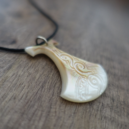 Pendentif Pénu en nacre de Tahiti, inspiré du pilon traditionnel polynésien. Monté sur lien ajustable noir, aux reflets clairs  irisés