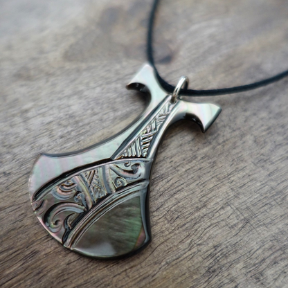 Pendentif Pénu en nacre de Tahiti, inspiré du pilon traditionnel polynésien. Monté sur lien ajustable noir, aux reflets irisés