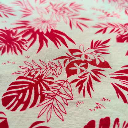 Zoom sur tissu tahitien en coton, cocotiers et feuillages rouge et beige. Edition limitée - aucun réassort