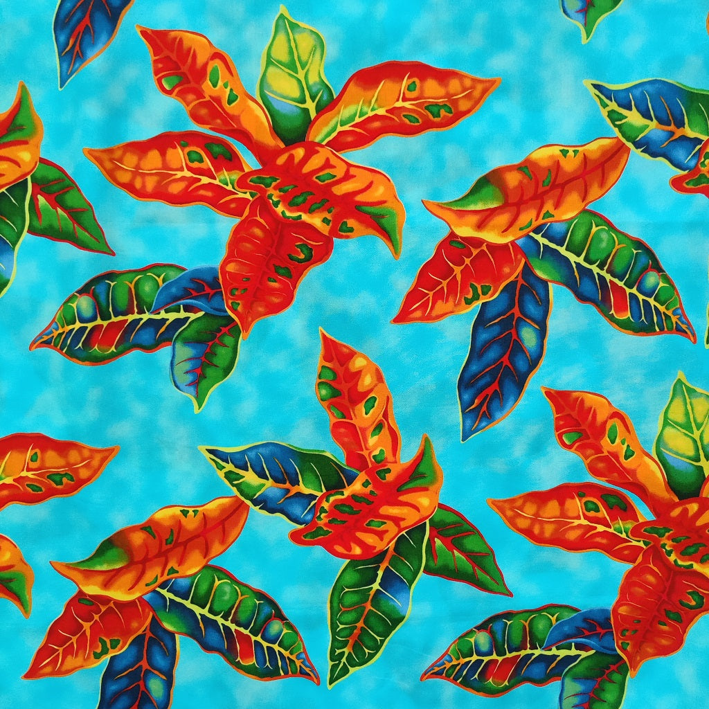 Tissu tahitien en coton, détails des motifs crotons orange et vert sur fond bleu turquoise. Tissu exclusif - dernier coupon.