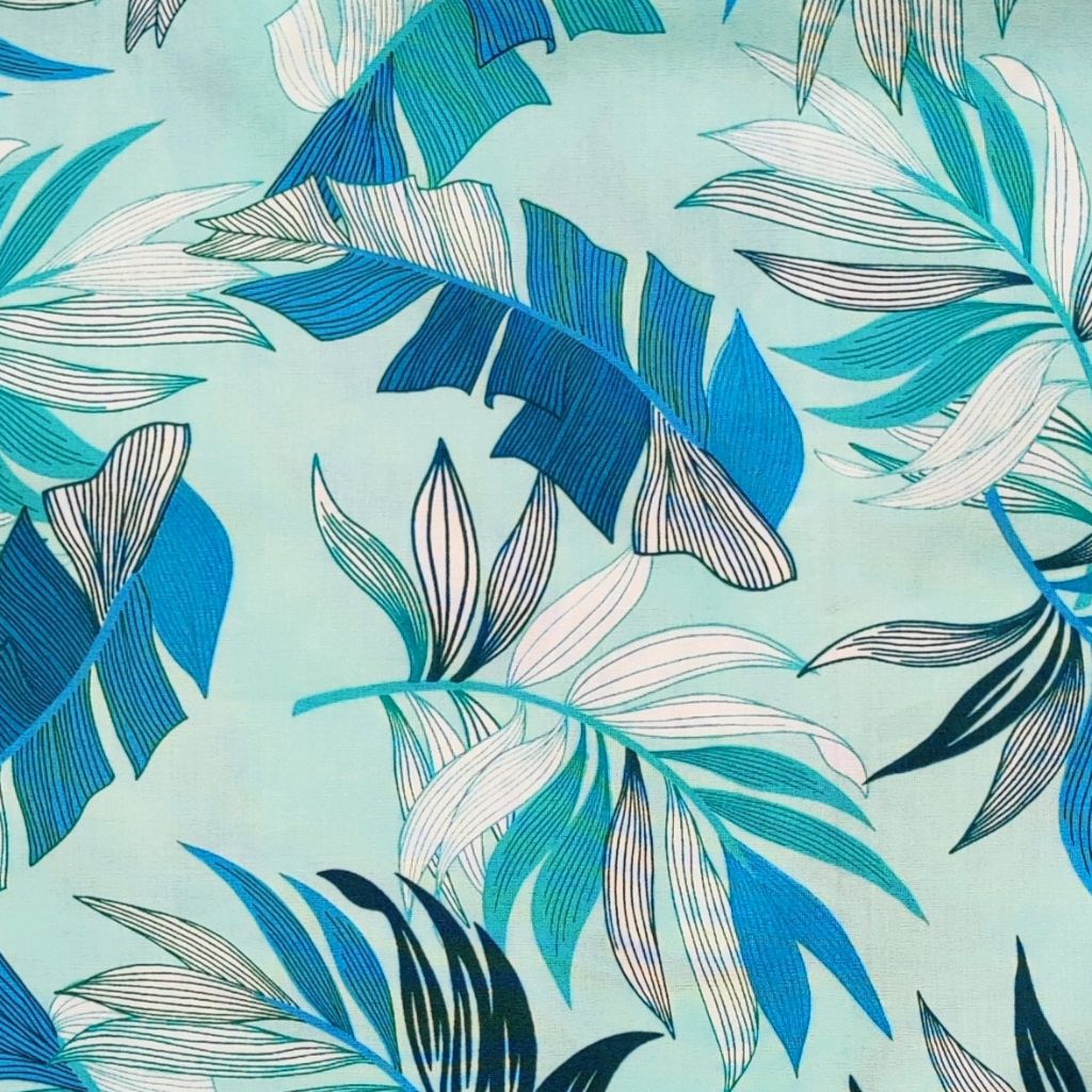 Tissu tahitien en coton, gros plan des motifs feuilles de bananiers et fougères , camaïeu de bleu. Stock limitée - aucun réassort.