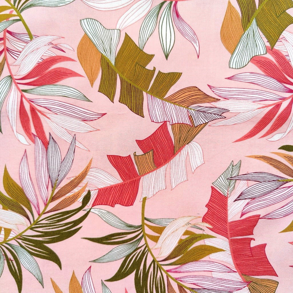 Tissu tahitien en coton, gros plan des motifs feuilles de bananiers et fougères , rose et vert kaki. Stock limité.