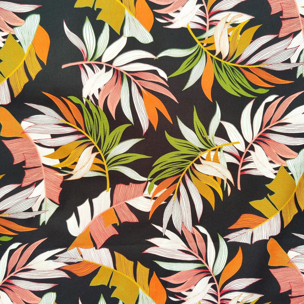 Tissu tahitien en coton, détails des motifs feuilles de bananiers et fougères vert et ocre sur fond noir intense. Edition limitée - aucun réassort.