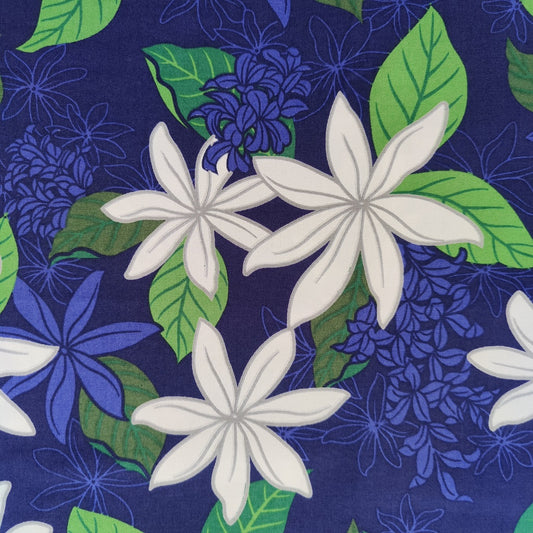 Tissu tahitien en coton, zoom sur les motifs fleurs de tiaré blanches sur fond bleu marine. Edition limitée - Aucun réassort.