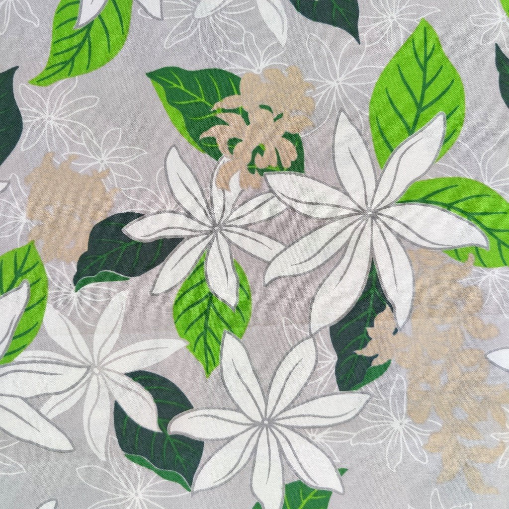 Tissu tahitien en coton, gros plan sur les motifs fleurs de tiarés blanches sur fond gris perle. Stock limité sur le site Couleurs du fénua