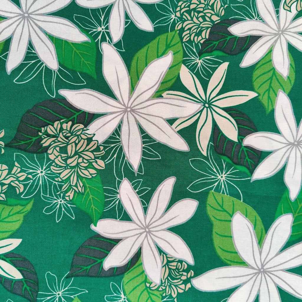 Tissu tahitien en coton, gros plan sur les motifs fleurs de tiarés blanches sur fond vert lumineux. Aucun réassort, strock très limité.