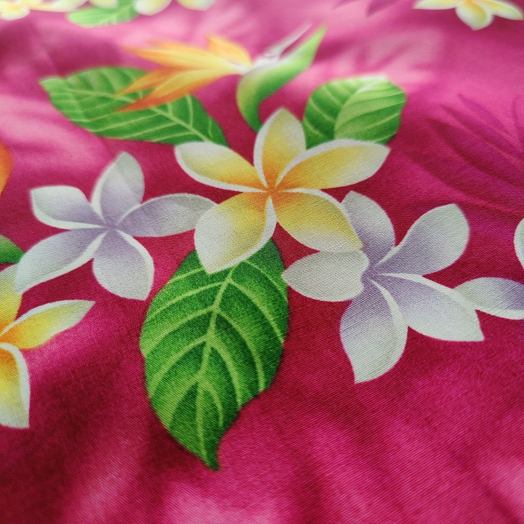 Tissu tahitien en coton, motifs frangipaniers et oiseaux de paradis jaune et blanc sur fond rose fuschia. Vendu au mètre.