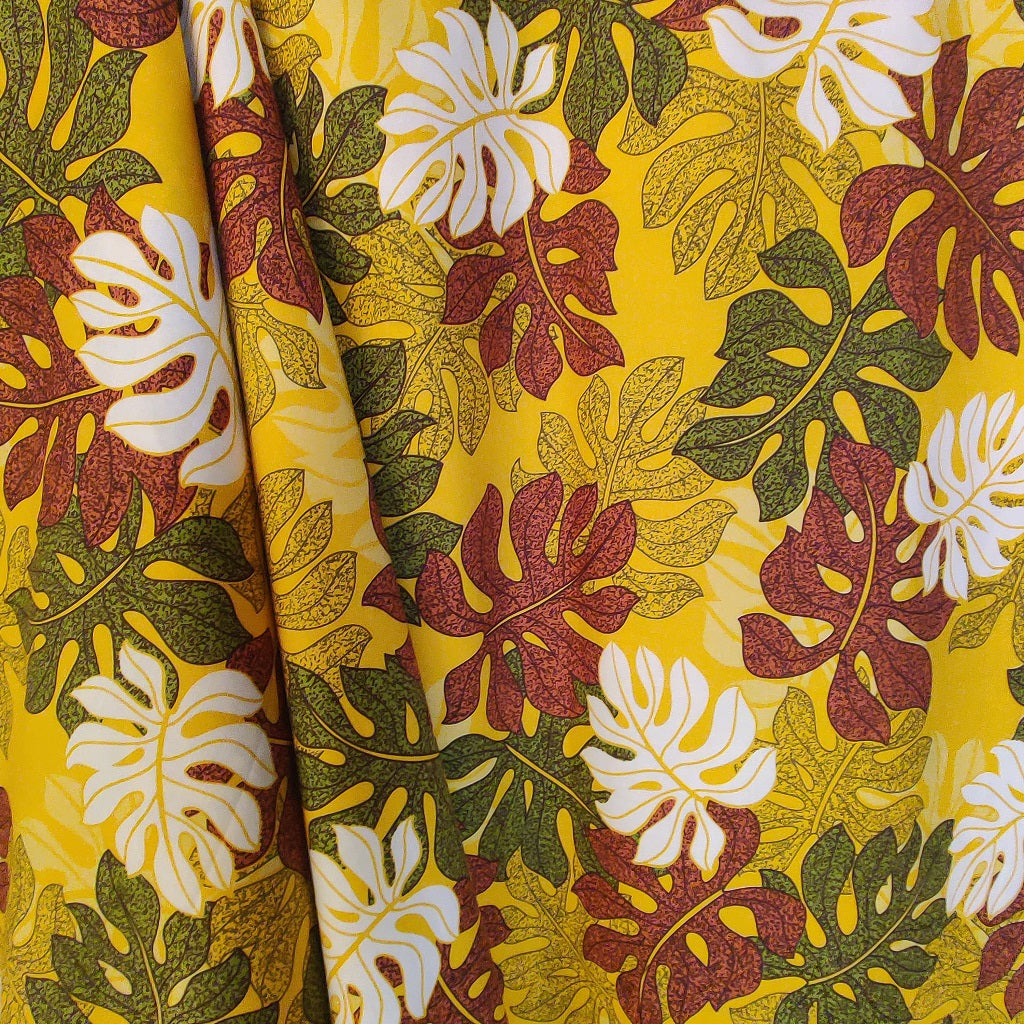 Tombé du tissu tahitien monstera marron vert et blanc sur fond jaune lumineux