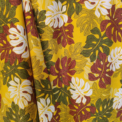 Tombé du tissu tahitien monstera marron vert et blanc sur fond jaune lumineux