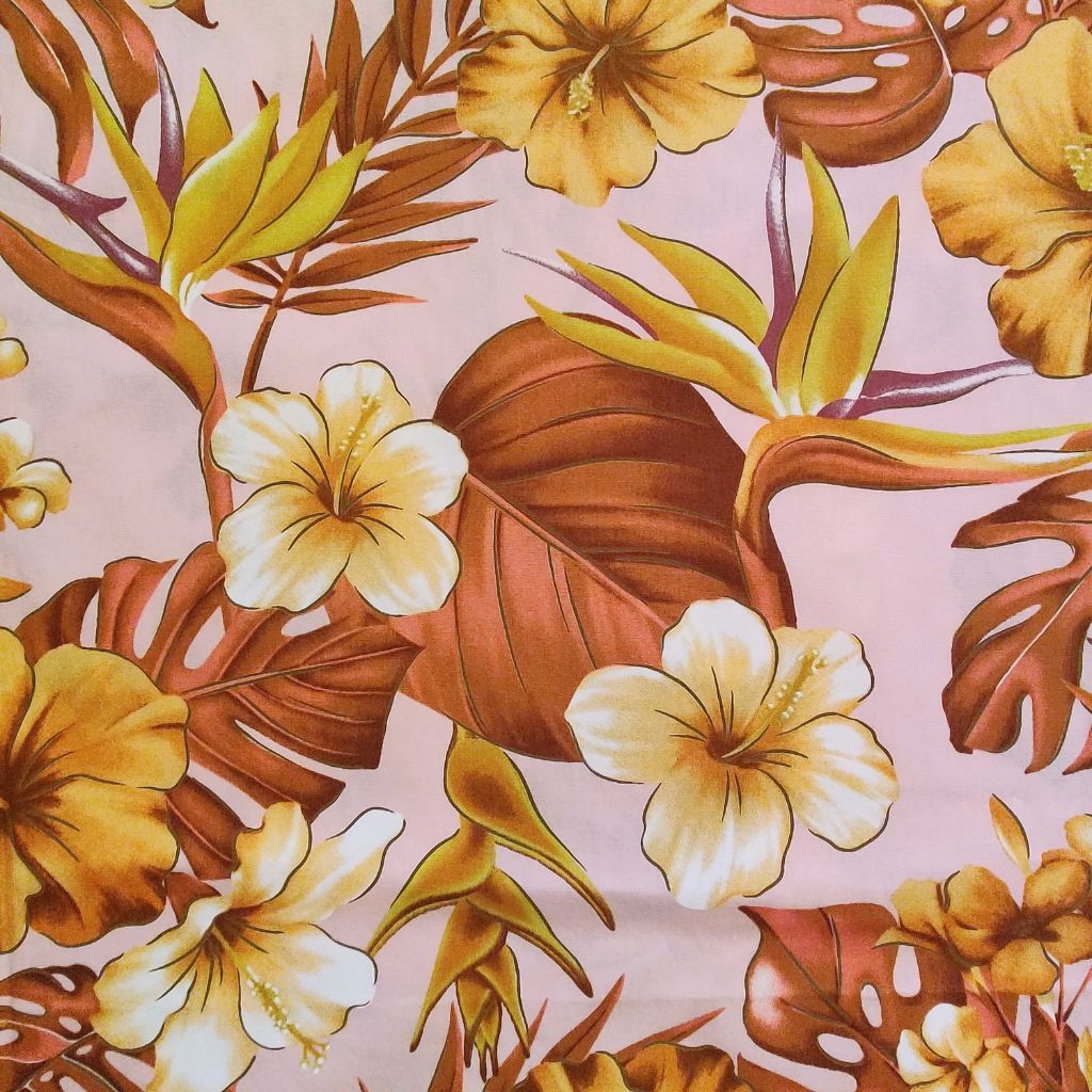Tissu tahitien en coton, zoom sur les motifs hibiscus monstera et oiseaux de paradis marron sur fond rose poudré. Edition limitée.