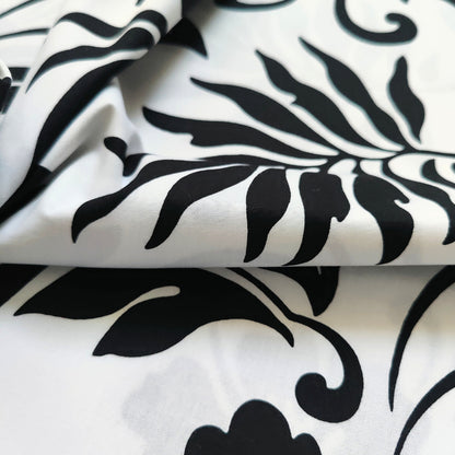 zoom sur le tissu coton polynésien motifs hibiscus et feuillages stylisés, noir et blanc